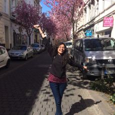 A young girl posing in front of the beautiful cherry blossom display in the old city "alt stadt" in Bonn, Germany.